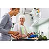 Senior woman/grandmother cooking in a modern kitchen (shallow DOF; color toned image)