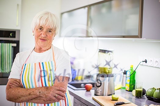 Senior woman/grandmother cooking in a modern kitchen (shallow DOF; color toned image) Senior woman/grandmother cooking in a modern kitchen (shallow DOF; color toned image)