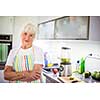 Senior woman/grandmother cooking in a modern kitchen (shallow DOF; color toned image)