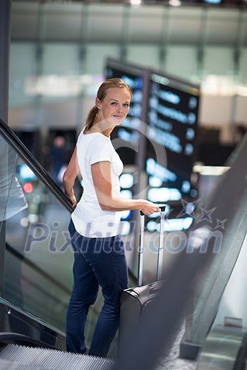 Young female passenger at the airport, transfering to her gate to board her flight on time(color toned image) Young female passenger at the airport, transfering to her gate to board her flight on time(color toned image)
