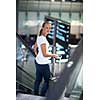 Young female passenger at the airport, transfering to her gate to board her flight on time(color toned image)