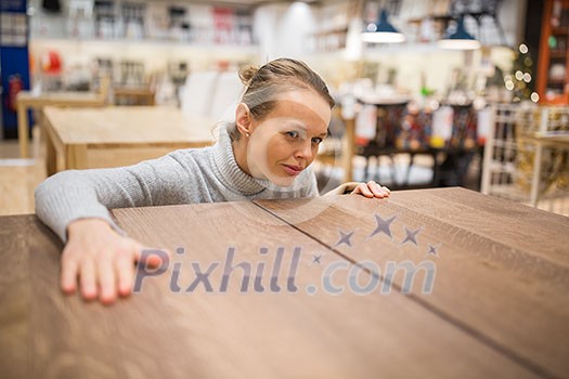 Pretty, young woman choosing the right furniture for her apartment in a modern home furnishings store (color toned image; shallow DOF) Pretty, young woman choosing the right furniture for her apartment in a modern home furnishings store (color toned image; shallow DOF)