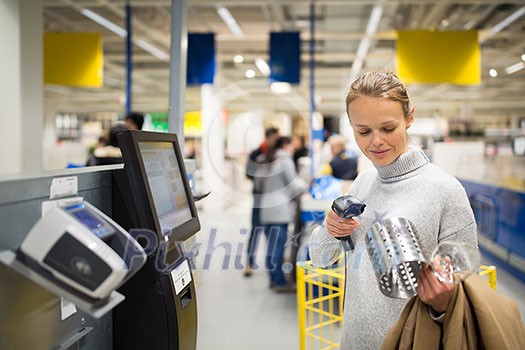 Pretty, young woman using self service checkout in a store (shallow DOF; color toned image) Pretty, young woman using self service checkout in a store (shallow DOF; color toned image)