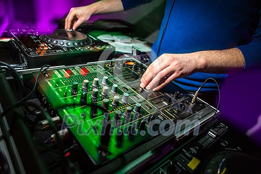 DJ's hands at the music mixer at a party - playing some fine songs for the guests (color toned image) DJ's hands at the music mixer at a party - playing some fine songs for the guests (color toned image)