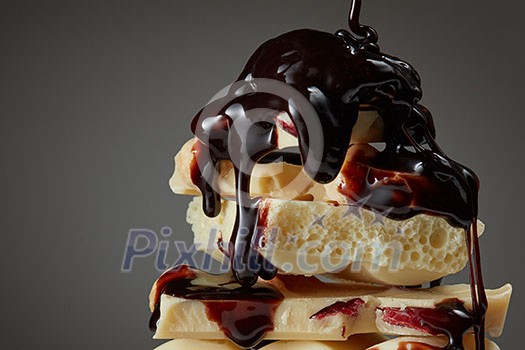 melted chocolate is poured on a stack of slices of milk chocolate melted chocolate is poured on a stack of slices of milk chocolate