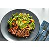 Overhead view of delicious, grilled meat duck with roasted pumpkin and fresh green herb salad on a plate