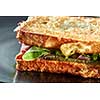 sandwich with ham and green salad grill on the black plate