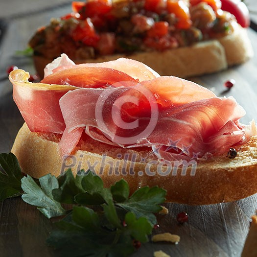 Italian bruschetta with parma ham on dark wooden background Italian bruschetta with parma ham on dark wooden background
