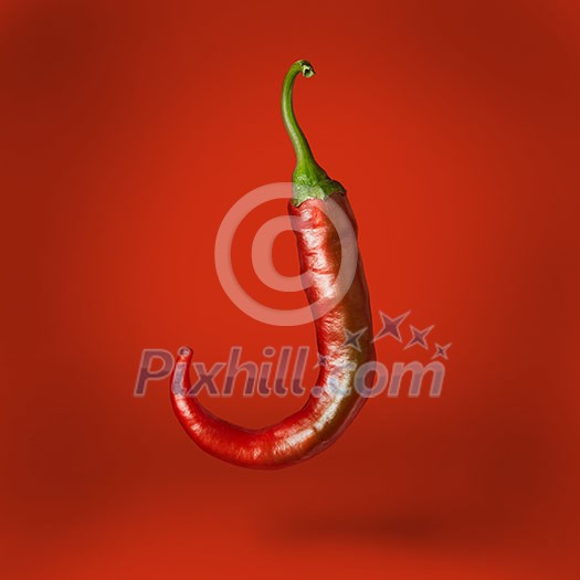 Hot chilli pepper floating over red background Hot chilli pepper floating over red background