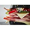 Burger with ham and black bun, with lettuce and mayonnaise and ketchup on white background. Macro