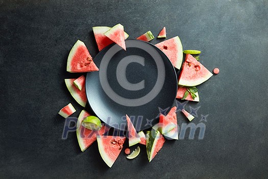 slices of watermelon placed in a circle of black plate. Space for text slices of watermelon placed in a circle of black plate. Space for text