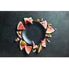 slices of watermelon placed in a circle of black plate. Space for text