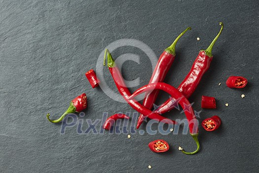 Sliced fresh red chillies isolated on a black concrete background Sliced fresh red chillies isolated on a black concrete background