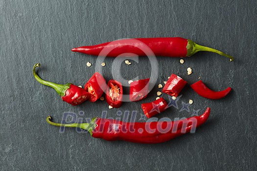 Red chili peppers chopped on a black concrete background Red chili peppers chopped on a black concrete background