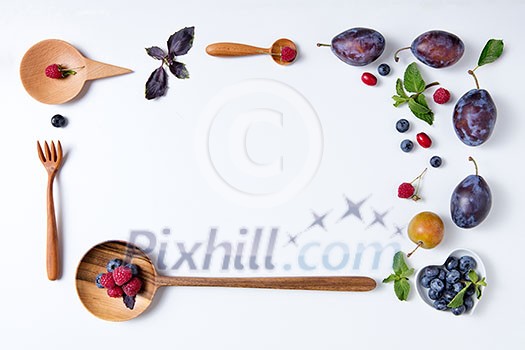 Plums and wooden spoons on a white background Plums and wooden spoons on a white background