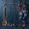 Fresh organic figs, dogwood, blueberries and plums in wooden spoons on wooden background. Frame with copy space.