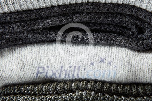 Stack of grey knitted clothes close up Stack of grey knitted clothes close up