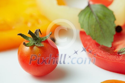 Tomato with green tail and pepper slices on a white background Tomato with green tail and pepper slices on a white background