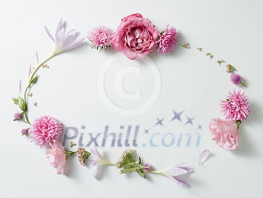 round frame wreath pattern with pink roses buds, branches and leaves with space for text isolated on white background. top view round frame wreath pattern with pink roses buds, branches and leaves with space for text isolated on white background. top view