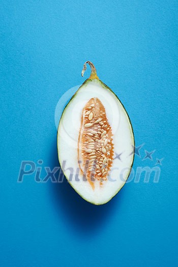 Close up of half melon on blue background isolated Close up of half melon on blue background isolated