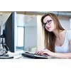 Pretty, female student looking at a desktop computer screen, learning unpleasant news about her exam results. University/office/school concept