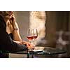 Man and a woman having drinks/glass of wine at a bar (shallow DOF; color toned image)