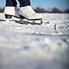 Young woman ice skating outdoors on a pond on a freezing winter day (color toned image; motion blurred image)