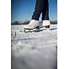 Young woman ice skating outdoors on a pond on a freezing winter day (color toned image; motion blurred image)