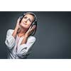 Pretty, young woman listening to her favorite music on hi-fi headphones, dancing, enjoying the tune, having a moment for herself