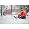 Ice skating concept - young woman sitting on the ice rink after falling down and hurting her knee