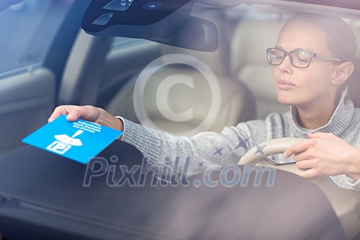 Pretty, young woman driving her new car - putting the necessary parking clock behind the windshield(color toned image; shallow DOF) Pretty, young woman driving her new car - putting the necessary parking clock behind the windshield(color toned image; shallow DOF)