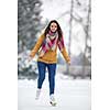 Young woman ice skating outdoors on a pond on a freezing winter day (color toned image; motion blurred image)