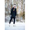 Young woman ice skating outdoors on a pond on a freezing winter day