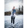 Young woman ice skating outdoors on a pond on a freezing winter day (color toned image; motion blurred image)