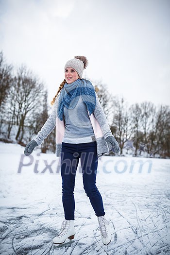 Young woman ice skating outdoors on a pond on a freezing winter day (color toned image; motion blurred image) Young woman ice skating outdoors on a pond on a freezing winter day (color toned image; motion blurred image)