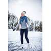 Young woman ice skating outdoors on a pond on a freezing winter day (color toned image; motion blurred image)