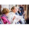 Gorgeous female tourist with a map discovering a foreign city (shallow DOF; color toned image)