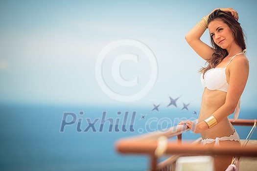 Beauty, spa and resort concept - beautiful, young woman by the sea on a balcony of a resort/hotel room Beauty, spa and resort concept - beautiful, young woman by the sea on a balcony of a resort/hotel room