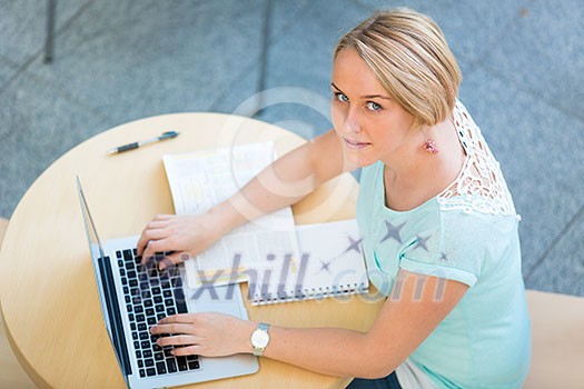 Pretty young female student with a laptop computer on college/university campus Pretty young female student with a laptop computer on college/university campus