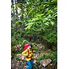 Pretty, young female hiker walking through a splendid old pine forest (shallow DOF)