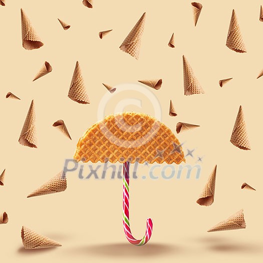 Umbrella made of waffle and waffle cones of rain on a yellow background. Umbrella made of waffle and waffle cones of rain on a yellow background.