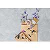 Composition of envelope over grey background with many ingredients in it. Notebook decorated with flowers. Copy space for your ideas and emotions.