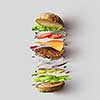 Top view of cheeseburger ingredients represented against white background. Hamburger or sandwich with cheese, tomato, beef, etc.