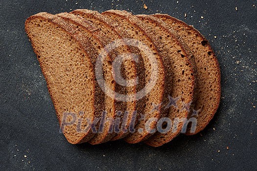 Many slices of delicious and fresh bread represented one after another isolated on black background. Slices of grain bread. Bread concept. Many slices of delicious and fresh bread represented one after another isolated on black background. Slices of grain bread. Bread concept.