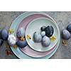 Easter eggs on blue plates on a concrete background