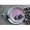 two plates with dyed eggs and a paper tray on a stone table