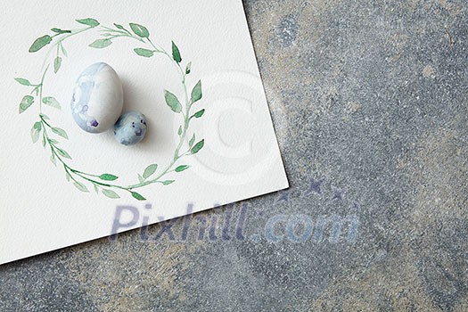 painted frame on paper and easter eggs on a concrete background