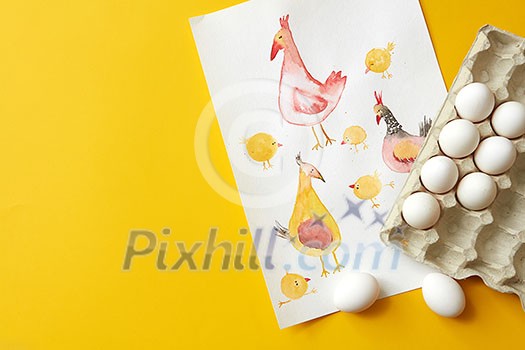 paper tray with eggs and chicken painted on a paper on the yellow background paper tray with eggs and chicken painted on a paper on the yellow background