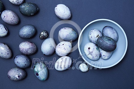Easter eggs on blue plate on a blue background, flat lay Easter eggs on blue plate on a blue background, flat lay