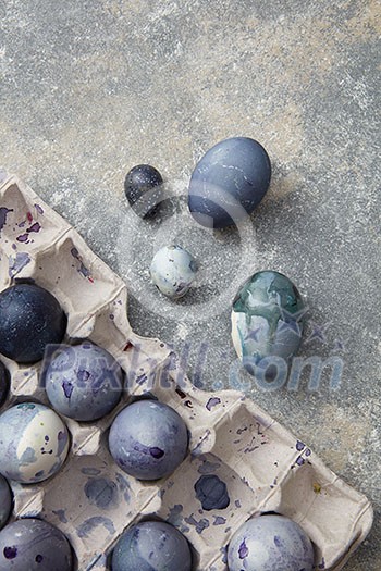 Many eggs of navy blue color represented in box over grey background. Beautiful composition of eggs foe making post card on Easter.
